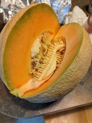 About to cut another slice. The cantaloupe this week is out of this world!