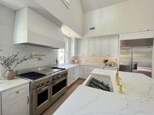 Spacious marble countertop kitchen with modern aesthetics. Golden details.