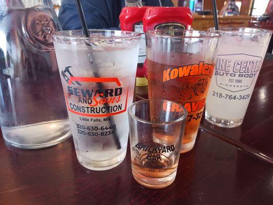 Water, Third Street Brewey cider, Lemonade. Glasses advertise local businesses.