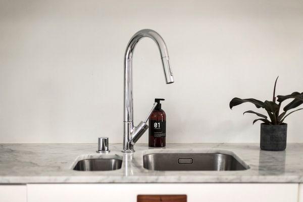 Marble countertops with integrated sinks, stainless steal faucets and leather handles.