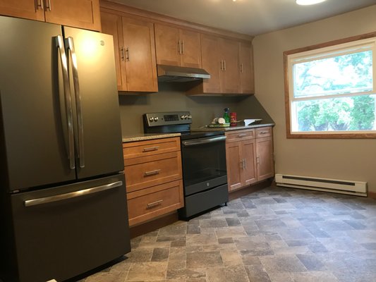 New kitchen, nearly completed showing new appliances, cabinets and flooring.