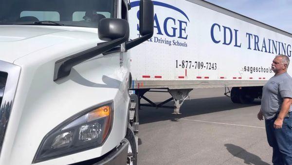 Sage student guiding heavyweight training truck on driving range.