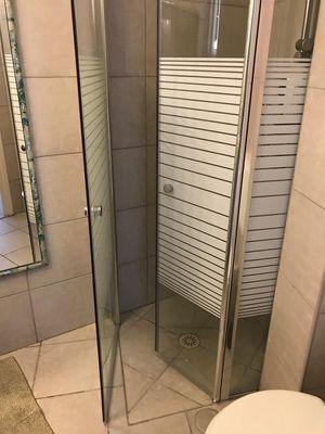 Shower door installation in small bathroom