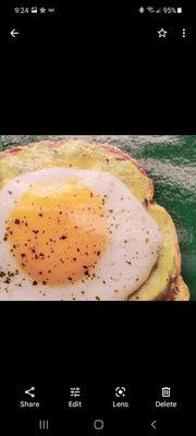 Sunnyside egg on top of toasted sourdough bread with a touch of avacado