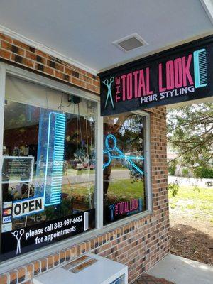 Look for the blue neon scissor and comb in the window