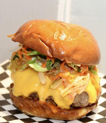 Gogi-Gooey Stuffed Burger. Patty stuffed with bulgogi beef, topped with kimchi slaw, American cheese, green onions and house gochujang aioli