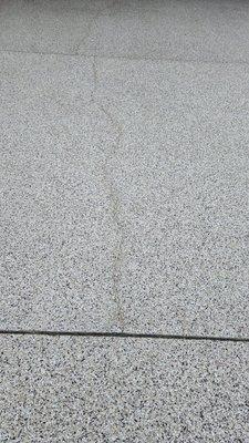 The existing concrete driveway crack reoccurred only one month after  Shark Skin Coating crack repair and new surface coating.