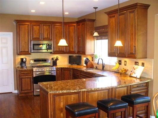 Burnished Cherry cabinets, granite countertops, tile backsplash and new lighting transformed this kitchen.