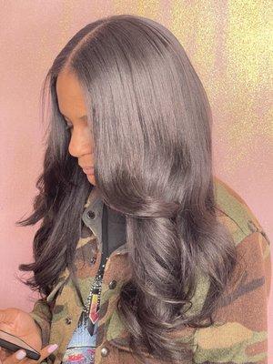 Middle part sew in extensions on kinky straight hair with some loose curls on the bottoms for good measure