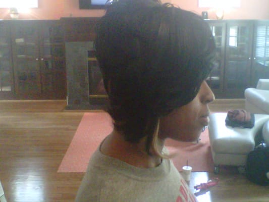 Short hairstyle with exaggerated bang and feathered. Weave pieces included in bang and razor cut for a dramtic effect.