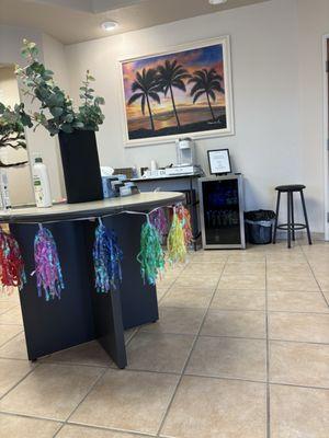 Table and fridge in the lobby. Fridge is stocked with juices, water, and a coffee station. There's also tooth brushes.