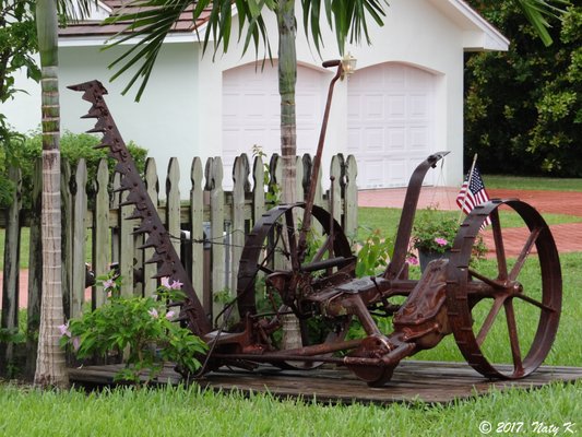 Farming tool on the side of the house.