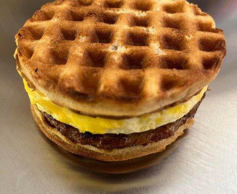 Breakfast sandwich with sausage egg and cheese on a homemade waffle