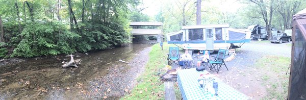 Panoramic of the site, stream, trees etc. very campground-esque.