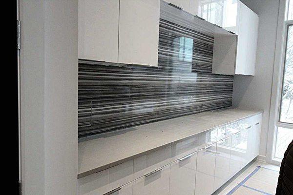 laundry room also has the black and white  backsplash and white cabinets