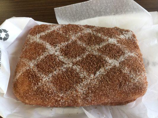 Apple and crème filled donut with brown and powdered sugar.  bomb dot com