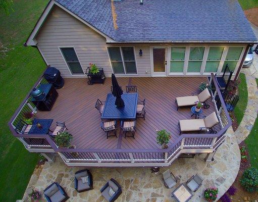 Trex deck with low maintenance handrail and stone patio with fireplace.