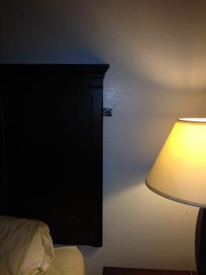 Here is the distant view of that hole containing electrical wires, it is partially hidden by the headboard.