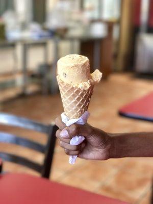 Butter pecan one scoop ice cream in waffle cone.