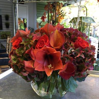 Dramatic amaryllis and warm rust hydrangea set this one apart from the ordinary.