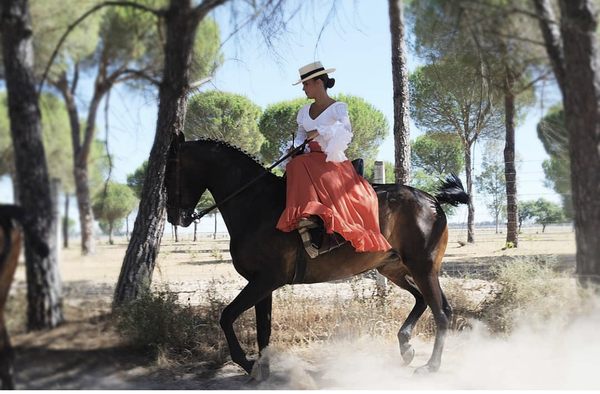 Lady riding side-saddle in Spain during the pilgrimage and festival of the Rocio held in Late Spring every year.