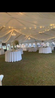 Beautiful sheer tent lining with cafe style lighting and chandeliers. Five foot round tables with linens.