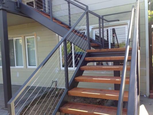 Redwood treads bolted onto the steel stringers leading up to second floor balcony from backyard