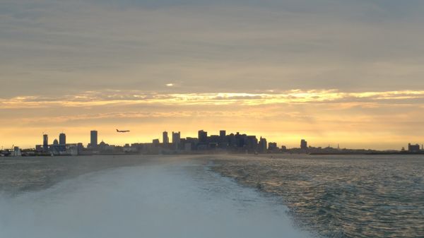 Boston skyline with a plane landing at BOS