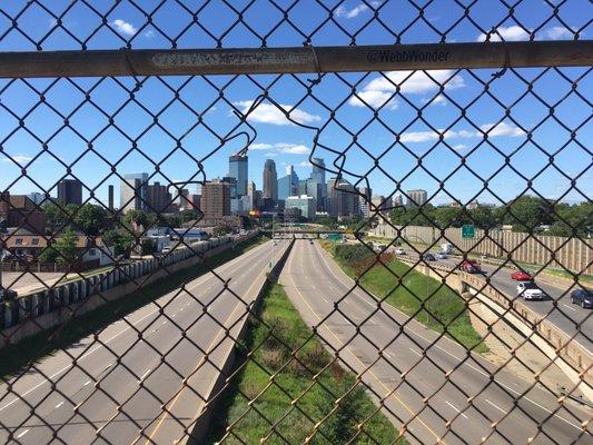 A number of people have cut holes in this fence to get a better shot of downtown. You can see these holes while driving on 35W below.