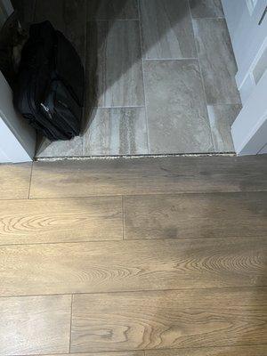 Transition between tile and hardwood floor between the garage and kitchen.