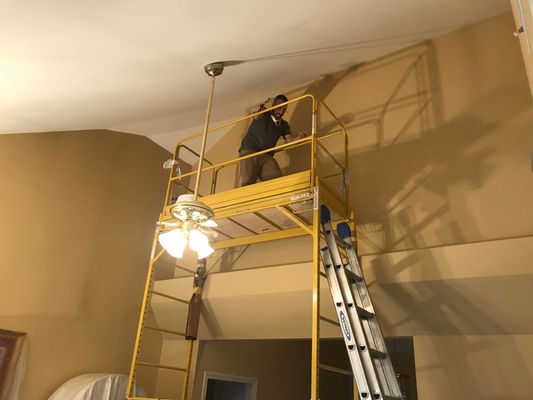 Working from staging to repair and paint a very tall ceiling