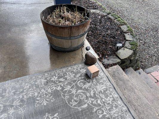 Carrier from this office tosses the package onto the edge of the porch in the rain.