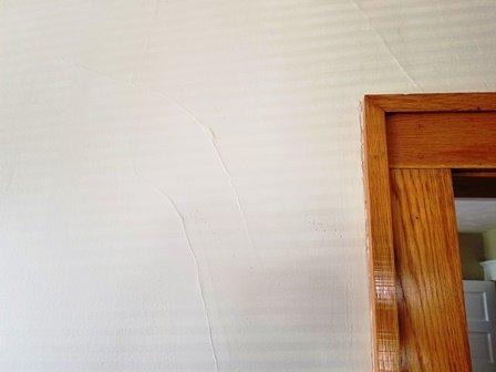 Hairline cracks in plaster finish wall.