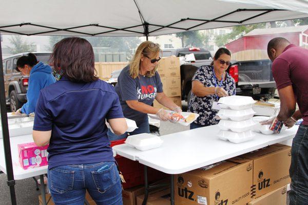 Volunteers from Ebenezer United Methodist Church and Shirley Heim Middle Schools serve food at a community cookout.