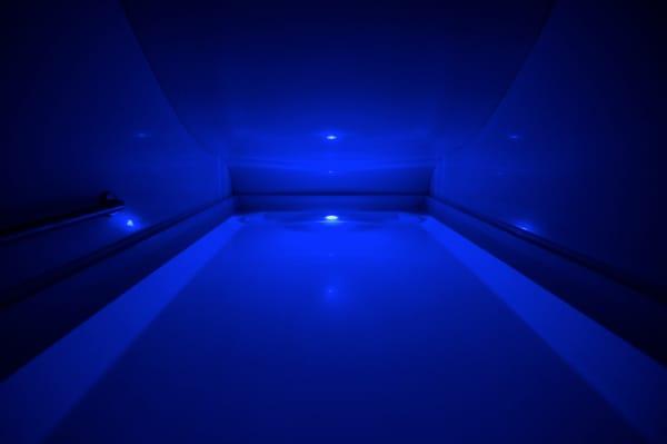 Inside of our Infinity Float Room! Large enough to walk into, stand up inside, and spread out, and you also control the soft blue light.