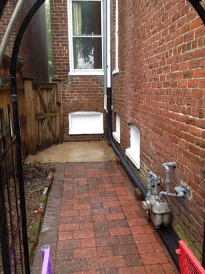 After... We removed the rain barrel, installed drainage, and power washed the concrete and brick.