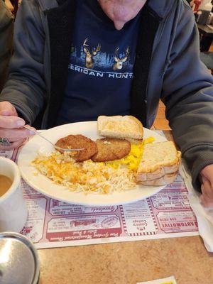 Scrambled eggs with toast, sausage,  and hash browns.