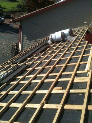 Wooden grid laid for a Steel Tile Product with Steel Tile and insulation roll ready for instalation.