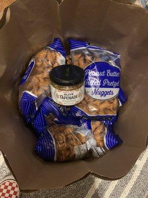 Someone loves us VERY much! 10 bags of Peanut Butter filled pretzel nuggets 16oz/$2.49 and 2 jars of olive tapenade $1.99 each. Both amazing