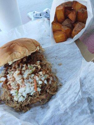 Pork sandwich with slaw, and potato logs.