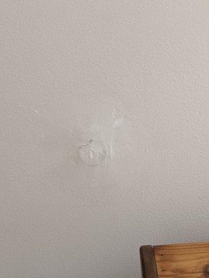 This hole in the wall was supposed to be patched. It is not.