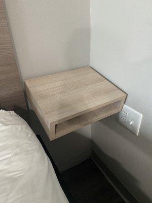 end table closest to the bathroom that is on a lean.