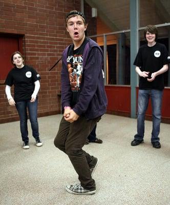 Lucy and Noah (backgroud) Cheer on Jake during a rehearsal warm-up