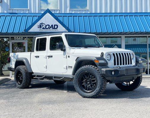 Jeep Gladiator with larger wheels and tires, side steps, and bed cover