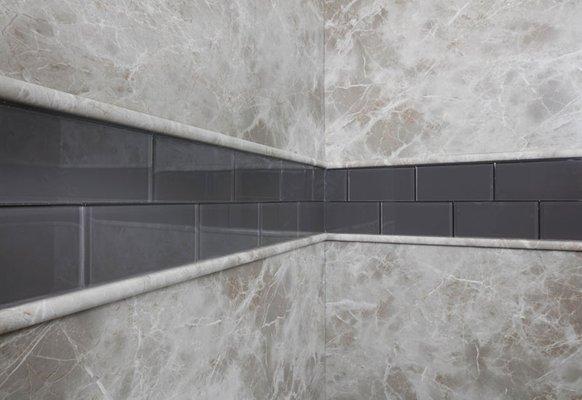 Custom grey shower walls with glass deco-tile accent.