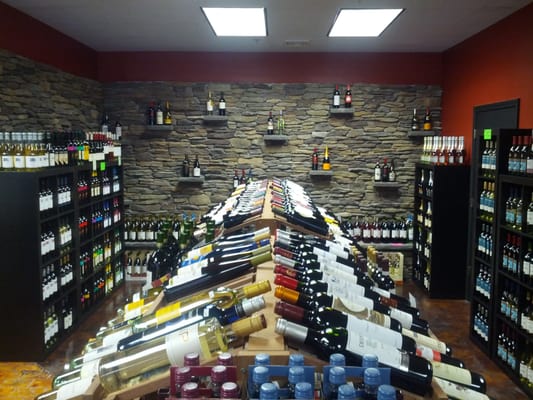 Fully stocked wine selection with beautiful stone wall to showcase our variety.