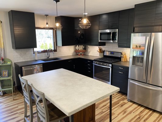 Ikea kitchen cabinets, new light fixtures, refinished island w/ concrete counter tops, and vinyl flooring.