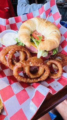 Lebanon bologna sandwich on croissant with onion rings