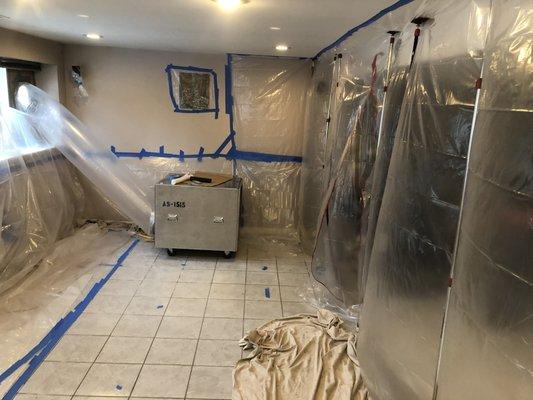 Containment walls and negative air unit create a negative pressure zone to trap mold spores