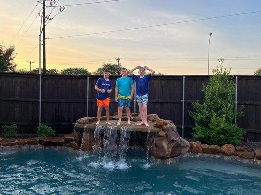 Some preteen guys are enjoying a pool party.